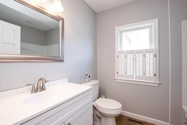 full bath with toilet, vanity, baseboards, and wood finished floors