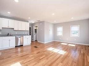 kitchen with stainless steel dishwasher, baseboards, white cabinets, open floor plan, and recessed lighting