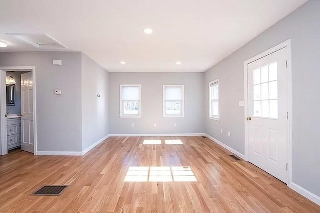 unfurnished living room with baseboards and light wood-style flooring