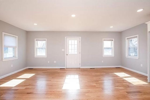 foyer entrance with healthy amount of natural light, baseboards, light wood-type flooring, and recessed lighting