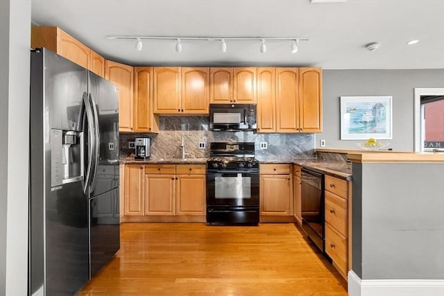 99 Washington St Unit 23, Salem, MA 01970 - kitchen featuring black appliances, light wood-type flooring, tasteful backsplash, and a peninsula
