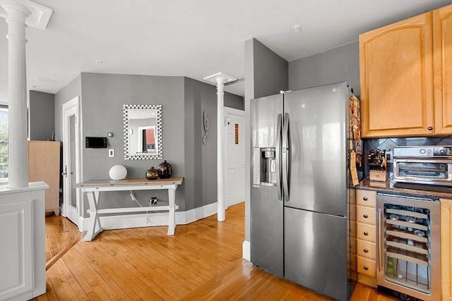 99 Washington St Unit 23, Salem, MA 01970 - kitchen featuring stainless steel fridge with ice dispenser, wine cooler, ornate columns, light wood finished floors, and light brown cabinets