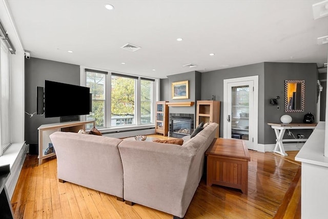 99 Washington St Unit 23, Salem, MA 01970 - living area with light wood finished floors, recessed lighting, a glass covered fireplace, and baseboards