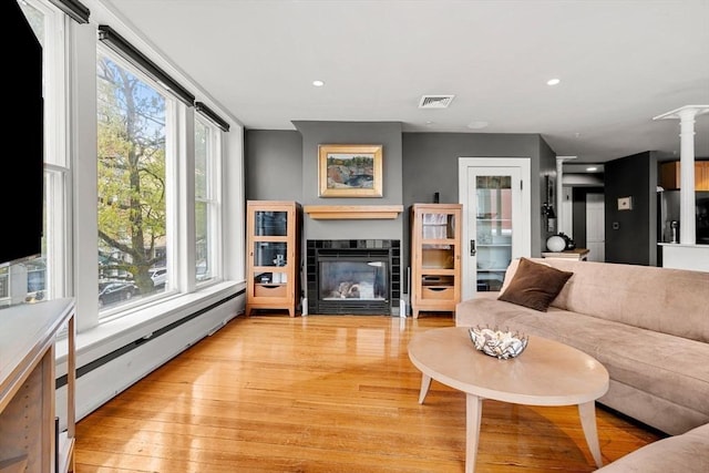 99 Washington St Unit 23, Salem, MA 01970 - living room with light wood finished floors, a tiled fireplace, decorative columns, a baseboard radiator, and recessed lighting