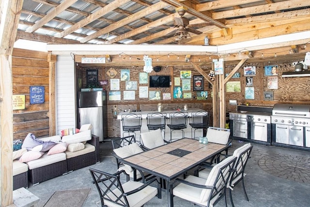 dining area with concrete flooring, wooden walls, and ceiling fan