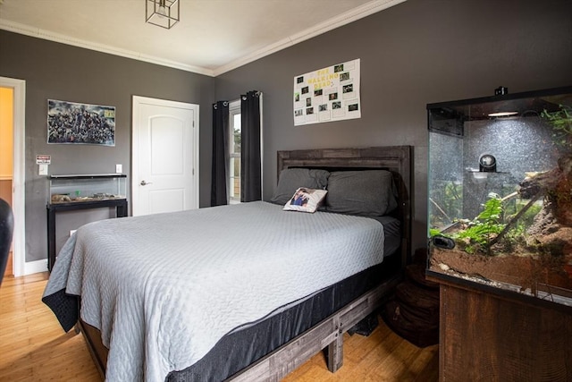 bedroom with wood finished floors and ornamental molding