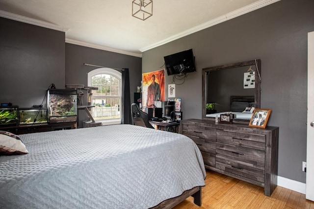 bedroom with wood finished floors, crown molding, and baseboards