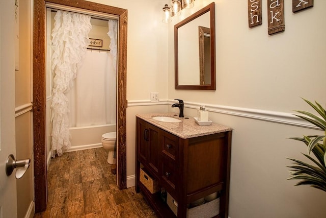 full bathroom with vanity, toilet, wood finished floors, and shower / tub combo with curtain