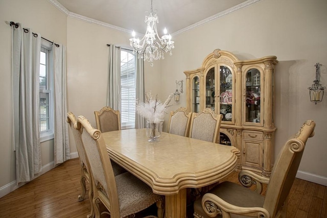 dining area with a chandelier, baseboards, wood-type flooring, plenty of natural light, and ornamental molding