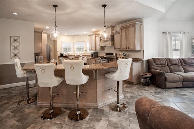 kitchen featuring appliances with stainless steel finishes, a breakfast bar, open floor plan, baseboards, and a kitchen island