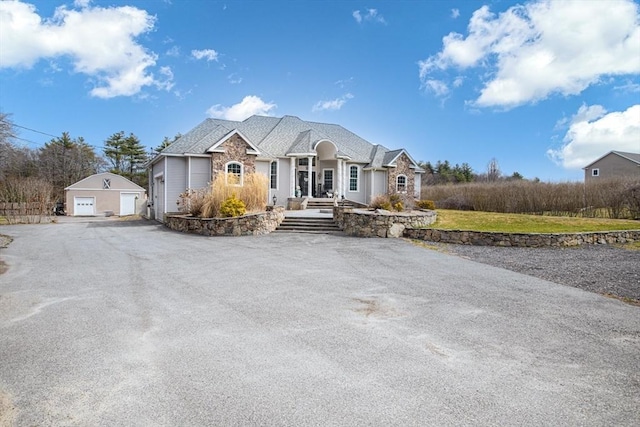 ranch-style home featuring a garage and an outbuilding