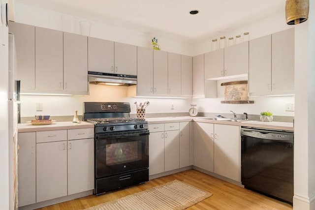 8 Oak St Unit 8, Cambridge, MA 02139 - kitchen with black appliances, under cabinet range hood, light wood-type flooring, and light countertops