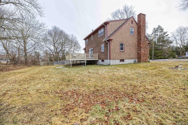 view of side of property featuring a wooden deck and a lawn