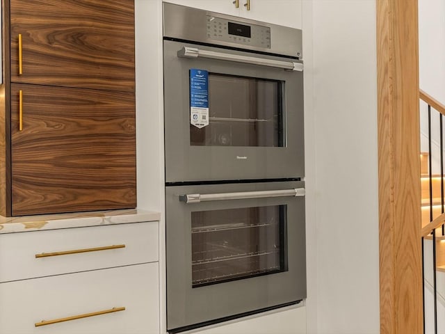 interior details featuring white cabinetry and double oven