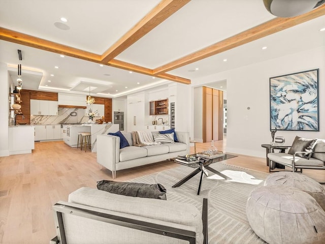 living room featuring light hardwood / wood-style floors and beamed ceiling