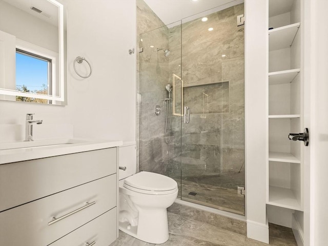 bathroom with toilet, a shower with shower door, and vanity