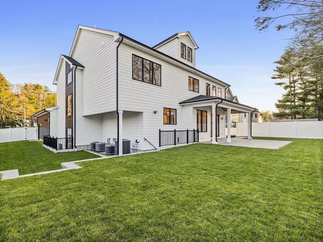 rear view of house featuring central AC, a lawn, and a patio