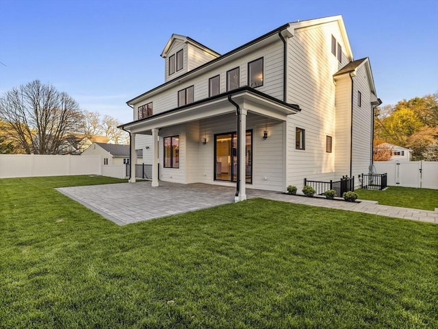 back of house featuring a lawn and a patio