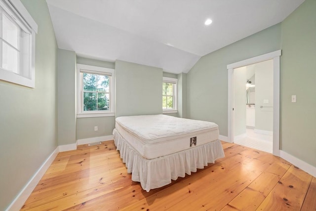 bedroom with light hardwood / wood-style floors and vaulted ceiling