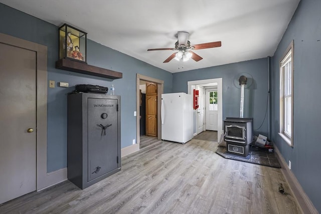 42 Briggs Ave, Pittsfield, MA 01201 - unfurnished living room featuring a wood stove, a ceiling fan, light wood finished floors, and baseboards