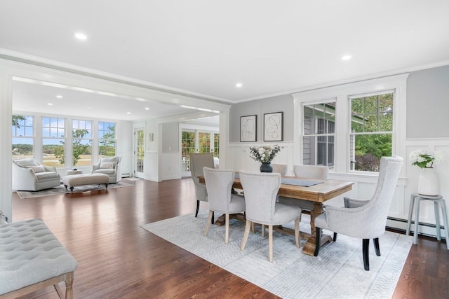 dining area with baseboard heating, a healthy amount of sunlight, crown molding, and dark hardwood / wood-style flooring