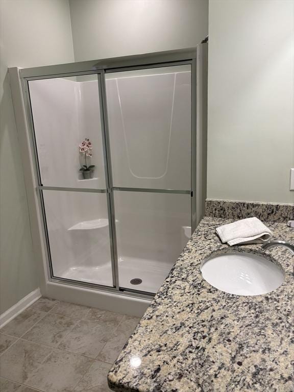 full bathroom featuring a stall shower, vanity, and tile patterned floors