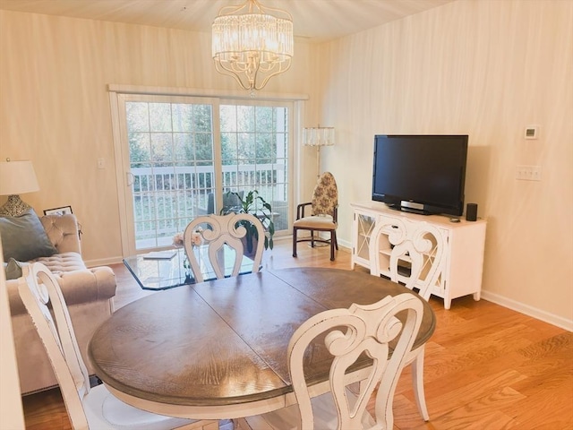 dining area with a notable chandelier, baseboards, and wood finished floors