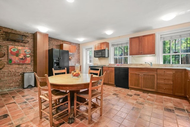 66 Rutland St, Boston, MA 02118 - kitchen featuring black appliances, brick wall, light countertops, brown cabinetry, and backsplash