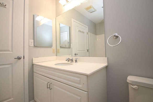 bathroom featuring visible vents, toilet, and vanity