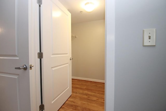 hall with baseboards and light wood-style flooring