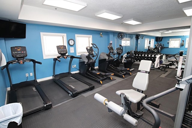 workout area featuring baseboards and a textured ceiling