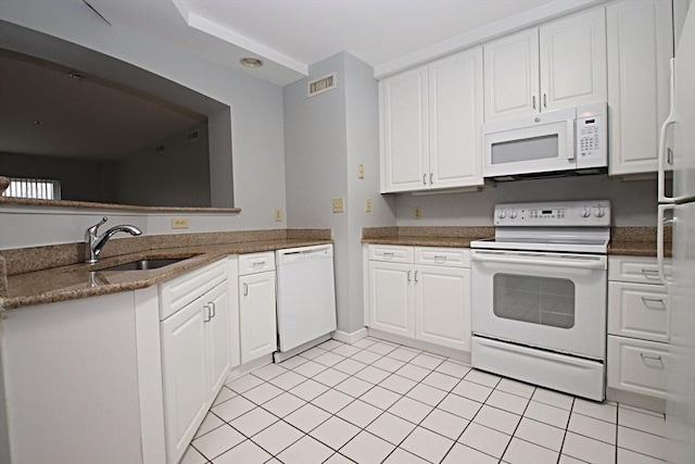 kitchen featuring visible vents, a sink, dark stone countertops, white cabinetry, and white appliances