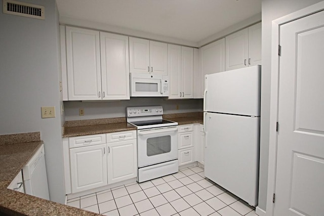 kitchen featuring white appliances, dark stone countertops, visible vents, light tile patterned flooring, and white cabinets