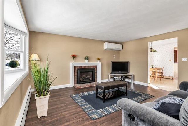 living area featuring a wall unit AC, a brick fireplace, a baseboard heating unit, and dark wood-type flooring