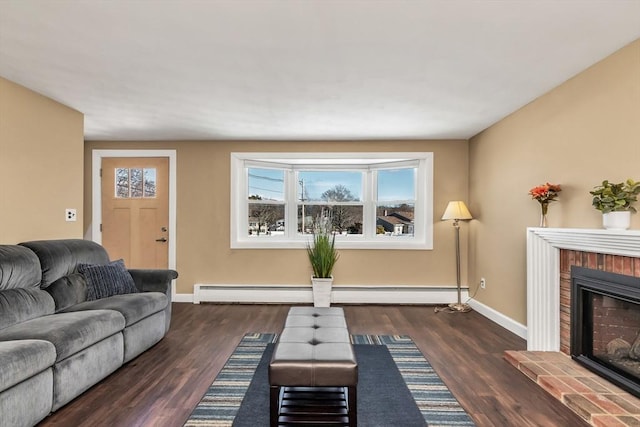 living area with a baseboard heating unit, a fireplace, wood finished floors, and baseboards