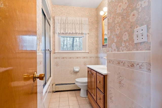 full bathroom with tile patterned flooring, toilet, a baseboard heating unit, bath / shower combo with glass door, and vanity