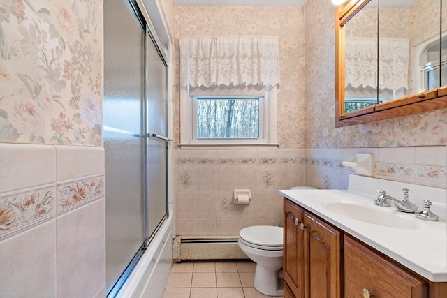 full bathroom featuring tile patterned flooring, toilet, vanity, shower / bath combination with glass door, and a baseboard radiator