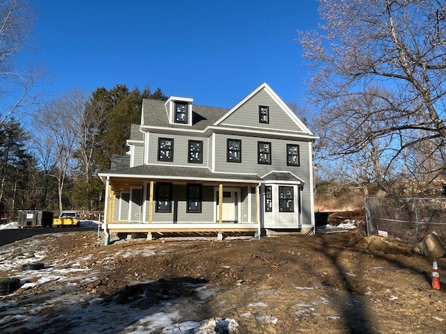 view of front facade featuring covered porch and roof with shingles