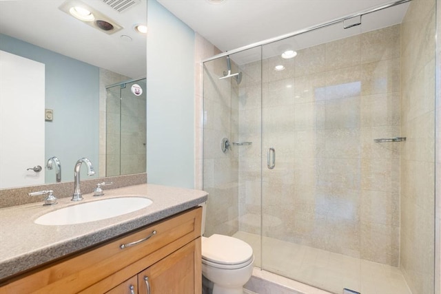 bathroom with vanity, an enclosed shower, and toilet