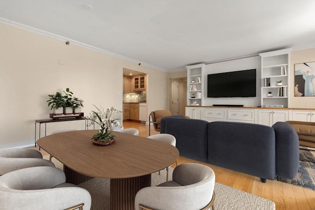 dining area featuring crown molding and light hardwood / wood-style flooring