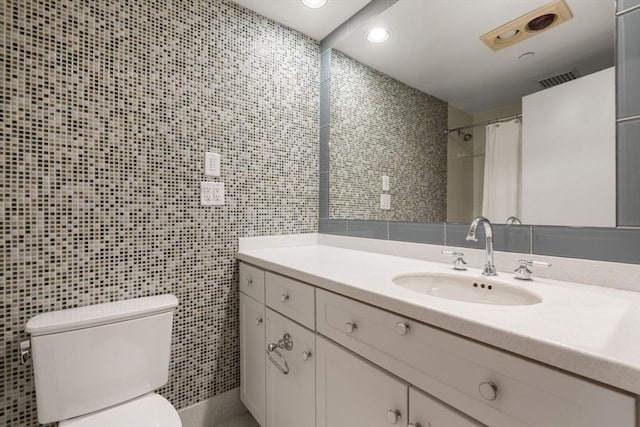 bathroom featuring a shower with curtain, vanity, toilet, and tile walls