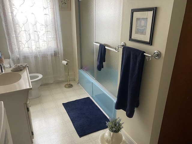 bathroom with enclosed tub / shower combo, toilet, vanity, baseboards, and tile patterned floors