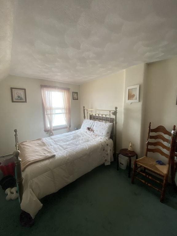 bedroom featuring a textured ceiling and carpet floors