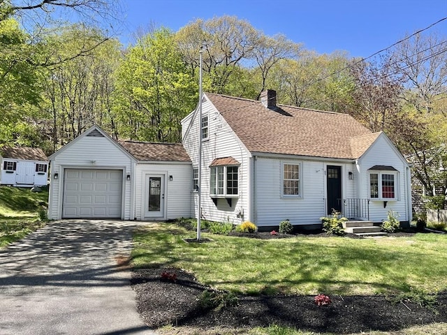 view of front of home with roof with shingles, an attached garage, a front lawn, aphalt driveway, and a chimney
