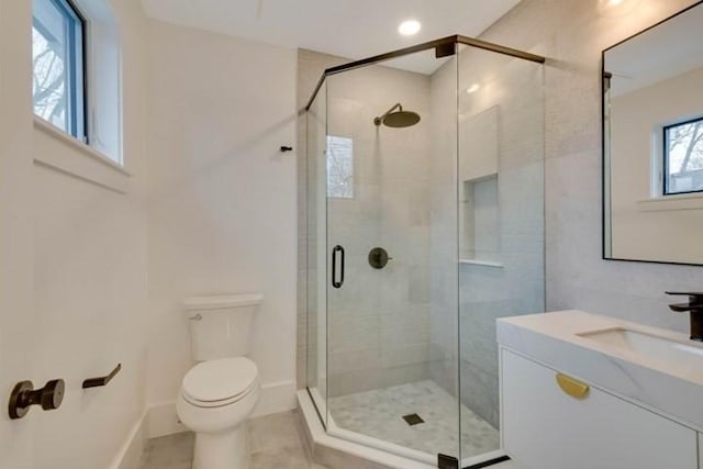 bathroom featuring toilet, vanity, baseboards, a shower stall, and tile patterned floors