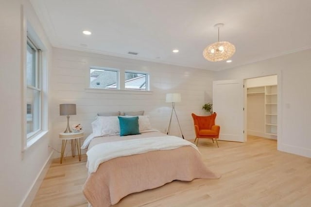 bedroom with ornamental molding, light wood finished floors, recessed lighting, and baseboards