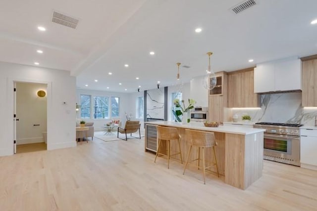 kitchen featuring stainless steel appliances, light wood-type flooring, modern cabinets, and visible vents