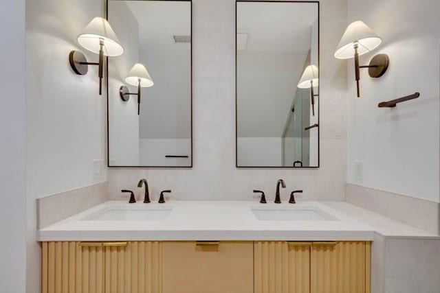 bathroom with double vanity, a sink, and visible vents