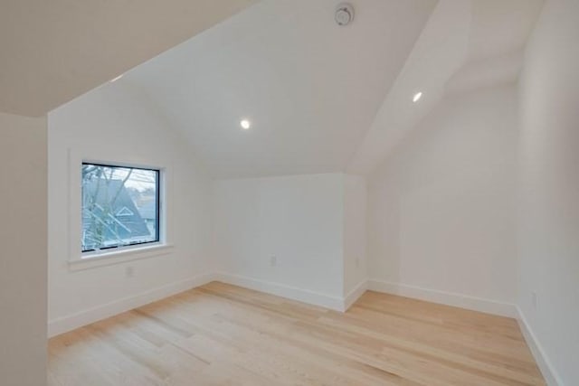 bonus room with lofted ceiling, light wood-type flooring, and baseboards