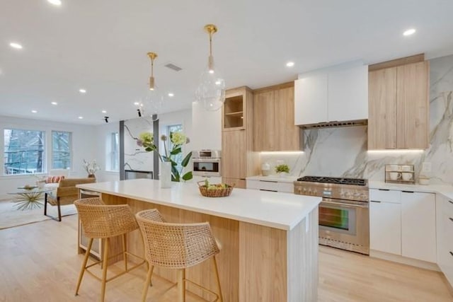 kitchen featuring visible vents, modern cabinets, appliances with stainless steel finishes, and a center island